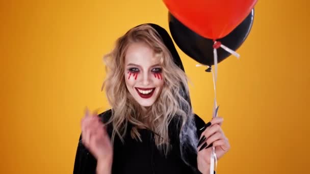 Счастливая Женщина Волшебник Черном Костюме Хэллоуин Макияж Позируя Воздушными Шарами — стоковое видео