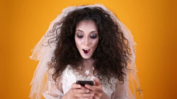 Щаслива Мертва Наречена Хеллоуїн Весільній Сукні Макіяжі Використовуючи Смартфон Помаранчевому — стокове відео