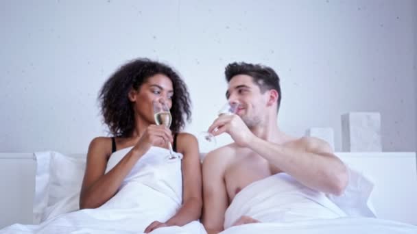 浪漫爱多民族夫妇喝香槟 而躺在床上 — 图库视频影像
