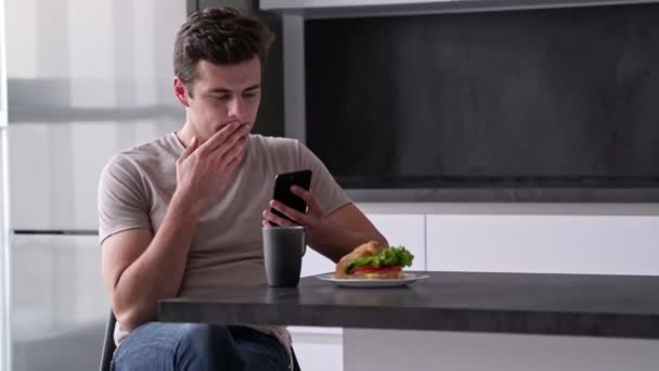 Lachende Man Met Behulp Van Smartphone Terwijl Zittend Bij Tafel — Stockvideo