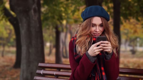 Mujer Morena Sonriente Boina Sombrero Abrigo Mensaje Escritura Teléfono Inteligente — Vídeo de stock