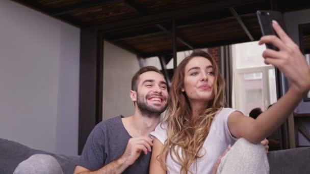 Kanepede Otururken Akıllı Telefonda Selfie Yapan Neşeli Sevimli Çift — Stok video