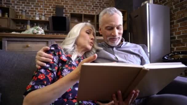 Alegre Casal Elegante Idosos Sentados Juntos Sofá Livro Leitura Casa — Vídeo de Stock