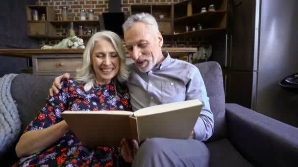 Ευτυχισμένο Ηλικιωμένο Κομψό Ζευγάρι Που Κάθονται Μαζί Στον Καναπέ Και — Αρχείο Βίντεο