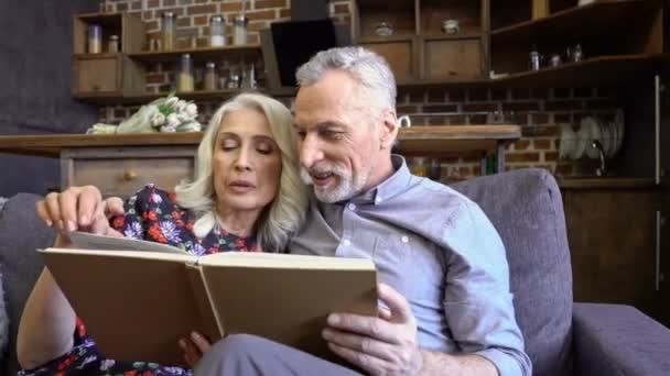 Agradável Casal Idosos Adoráveis Lendo Juntos Enquanto Sentados Juntos Sofá — Vídeo de Stock