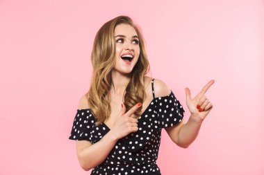 Mutlu genç güzel kadın pembe duvar arka plan copyspace gösteren izole poz.