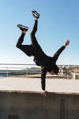 Avrupalı adamın akrobasi yaptığı ve kollarında durduğu fotoğraf 