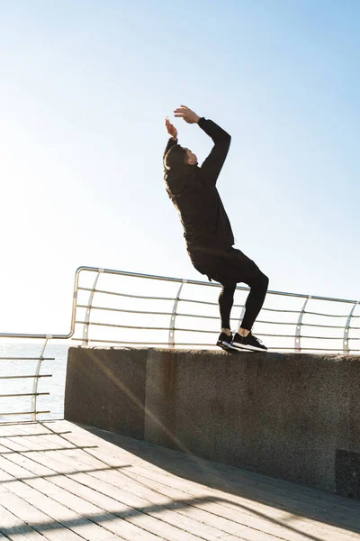 Foto de un tipo fuerte de 20 años haciendo acrobacias y saltando durante la mañana — Foto de Stock