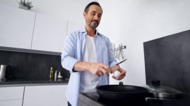 Evde mutfakta dururken mutlu olgun adam kahvaltı pişirme