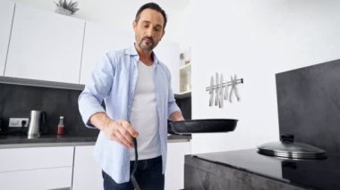 Evde mutfakta dururken konsantre olgun adam kahvaltı pişirme