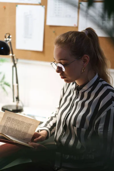 Foto einer blonden europäischen Architektin mit Brille, die Entwurf entwirft und am Arbeitsplatz sitzt — Stockfoto