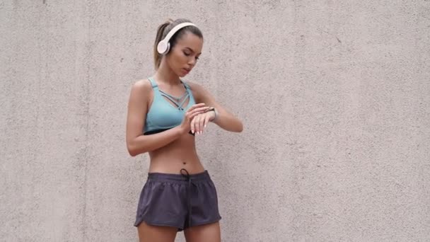 Улыбающаяся Спортсменка Наушниках Слушает Музыку Танцует Стены Открытым Небом — стоковое видео
