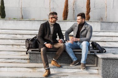 Palto giyen iki yakışıklı adam vakit geçiriyor