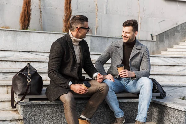Два красивих чоловіка в пальто проводять час — стокове фото