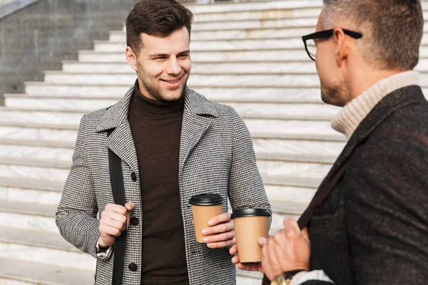 Two handsome men wearing coats spending time — Stock Photo, Image