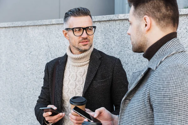 Two handsome men wearing coats spending time — Stock Photo, Image