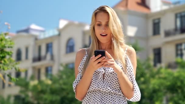 Happy Blondy Woman Dress Using Smartphone Rejoices While Standing Park — Stock Video