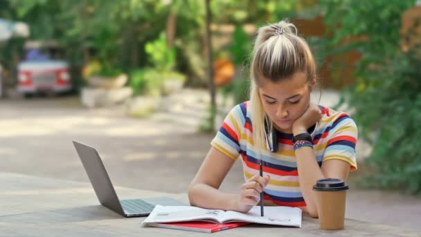 Konzentrierte Hübsche Studentinnen Lesen Etwas Während Sie Tisch Mit Laptop — Stockvideo