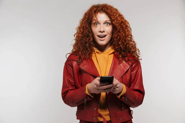 Portrait of stylish redhead woman 20s wearing leather jacket smi