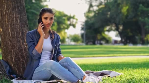 Femme Brune Souriante Parlant Par Smartphone Tout Étant Assis Près — Video