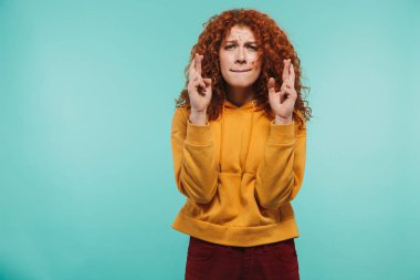 Kıvırcık zencefil saçlı 20'li yaşlarda parmak tutan genç kadın görüntüsü 