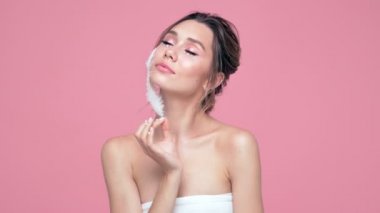 Güzellik pembe arka plan üzerinde turba ile poz yüzünde ve elleri inci ile esmer kadın memnun