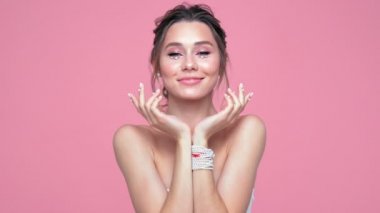 Güzellik pembe arka plan üzerinde poz yüzünde ve elleri inci ile esmer kadın memnun