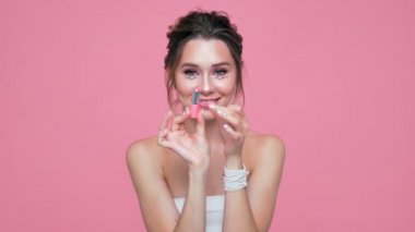Yüzü ve elleri pembe arka plan üzerinde pomade ile poz inci ile Güzellik mutlu esmer kadın