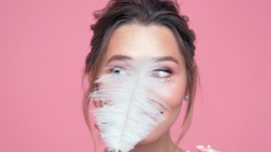 Pembe arka plan üzerinde turba ile poz yüzünde ve elleri inci ile Güzellik eğlenceli esmer kadın yakından görünümü