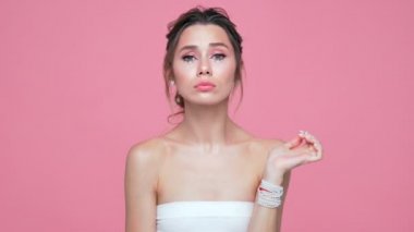 Yüzü ve elleri pembe arka plan üzerinde poz inci ile Güzellik çekici esmer kadın