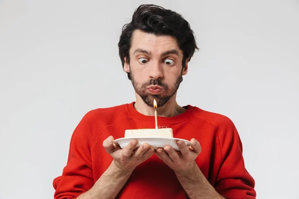 Νέοι ενθουσιασμένος άνθρωπος που θέτουν απομονωμένα πάνω από λευκό τοίχο φόντο κρατώντας τούρτα γενεθλίων. — Φωτογραφία Αρχείου