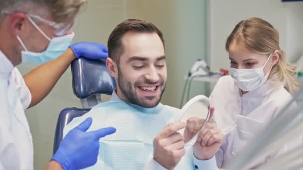 Beuatiful Morena Homem Sorrindo Olhando Para Espelho Após Procedimento Odontológico — Vídeo de Stock