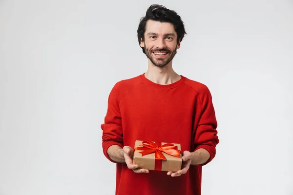 잘 생긴 젊은 흥분 남자 포즈 고립 위에 흰색 벽 배경 보유 선물 선물 상자. — 스톡 사진