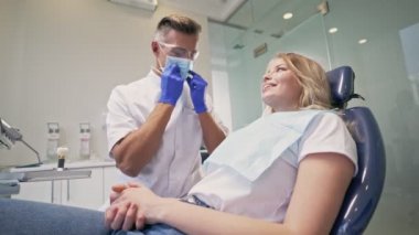 Diş kliniğinde kontrol işleminden sonra diş ve ekrana bakarken diş ile ilgili sorun hakkında diş hekimi dinleme konsantre sarışın kadın