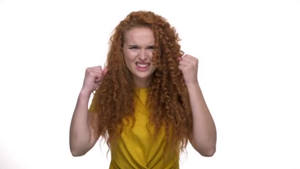 怒っている若い赤毛の巻き毛の女性は非常に大声で叫び 孤立した白い背景の上にカメラを見ながら手でジェスチャー — ストック動画