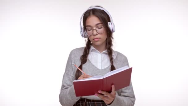 Jovem Estudante Morena Concentrada Sorrindo Fazendo Anotações Caderno Enquanto Ouve — Vídeo de Stock