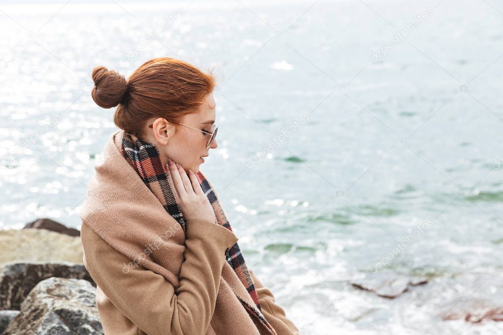 Lovely young redhead woman wearing autumn coat