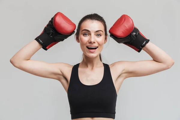 Young sport fitness woman boxer isolated over grey wall background make exercises in gloves. — Stock Photo, Image