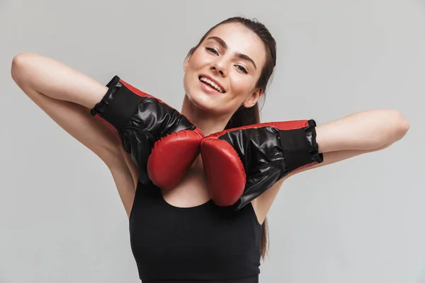 Young Sport Fitness vrouw Boxer geïsoleerd over grijze muur achtergrond maken oefeningen in handschoenen. — Stockfoto