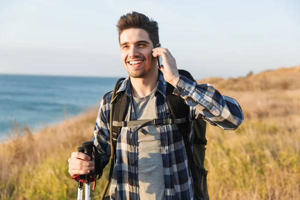 Happy young man outside in free alternative vacation camping talking by mobile phone. — Stock Photo, Image