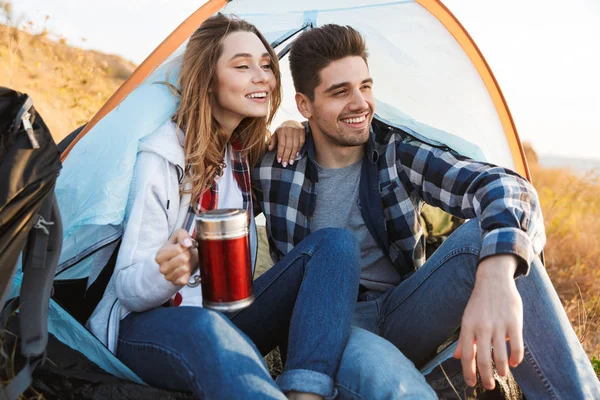 Gelukkig jong liefdevolle paar buiten in gratis alternatieve vakantie Camping drinken hete thee. — Stockfoto