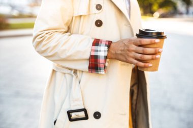 Yong kafkas kadının şehir caddesinde yürürken paket kahve içerken çekilmiş fotoğrafı