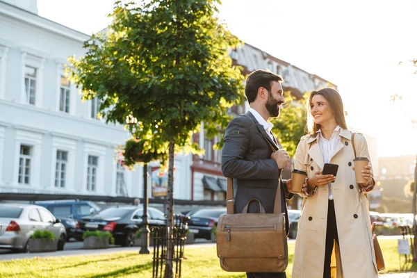 Portré kaukázusi üzleti pár férfi és nő iszik Elvihet kávét, és beszél együtt, míg találkozó a város utcán — Stock Fotó