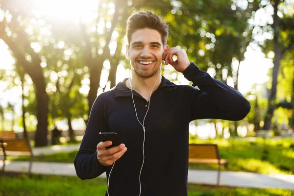 Porträtt av kaukasiska Athletic man lyssna på musik med earph — Stockfoto