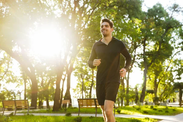 Portrait of attractive athletic man running while doing workout — Stock Photo, Image