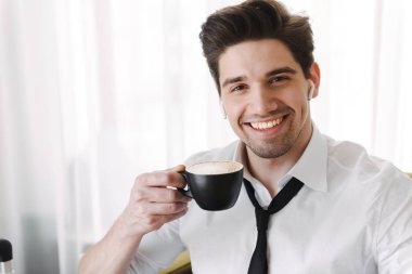 Bir otelde koltukta oturan yakışıklı genç işadamı