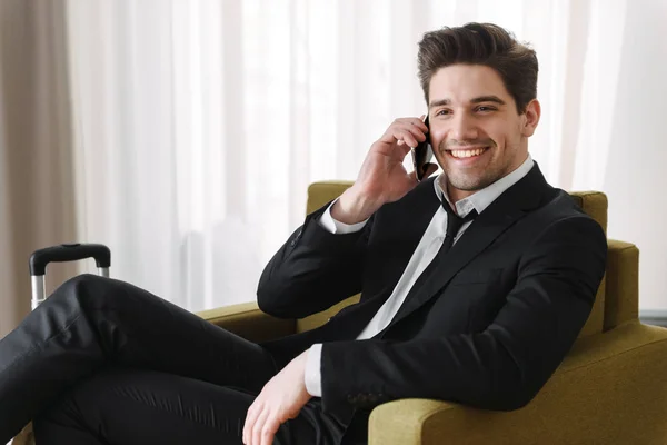 Koltukta oturan takım elbise giyen kendine güvenen yakışıklı adam — Stok fotoğraf