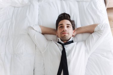 Otel dairesinde yatakta yatan Avrupa sakinleştirici işadamının tepesinden fotoğraf