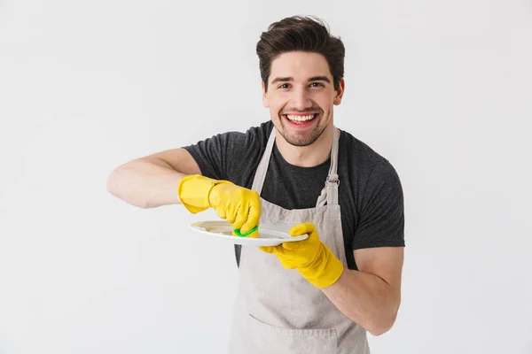 Fotografie radostného mladého muže, který nosí na rukou žluté gumové rukavice — Stock fotografie