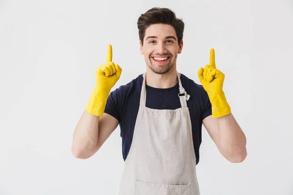 Foto de jovem alegre vestindo luvas de borracha amarela para han — Fotografia de Stock